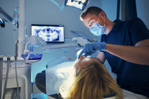 a dentist performs a routine dental exam