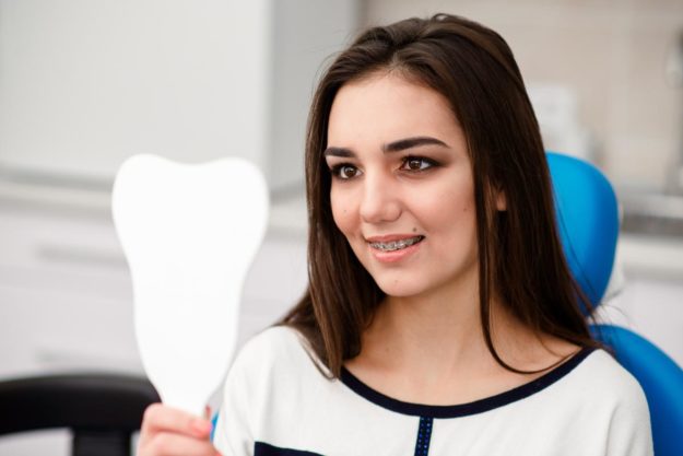 5 Signs You Need Dental Braces Again (5) adult patient looking at dental braces